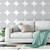 Gray couch with mint green throw blanket in front of removable gray circles wallpaper