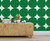 Rustic side table with lamp candles and books on top in front of green circles wallpaper