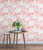 coral colored palm leaf silhouette wallpaper behind a table with a plant
