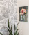 Walls with black and white floral wallpaper and a pink flower painting