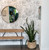 Entry way with round mirror, plant, and bench with hand drawn floral wallpaper