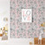 Children's room with a stuffed bunny on a bench, a poster that says love, and sketched floral wallpaper with a pink background. 