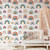 Nursery with a white crib and peach colored canopy with colorful rainbow wallpaper
