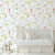 A nursery with a crib and removable wild flower wallpaper