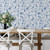 Dining room with table and chairs and blue botanical wallpaper