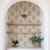 Arched nook bar area featuring abstract leaf wallpaper, wine bottles and a plant on the counter