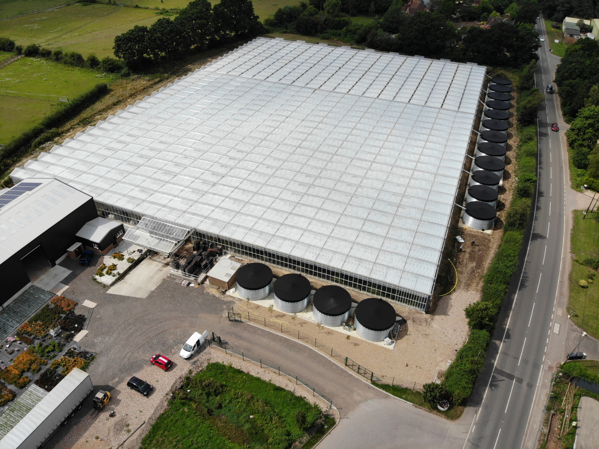 Mostly glass building surrounded by circular metal silos