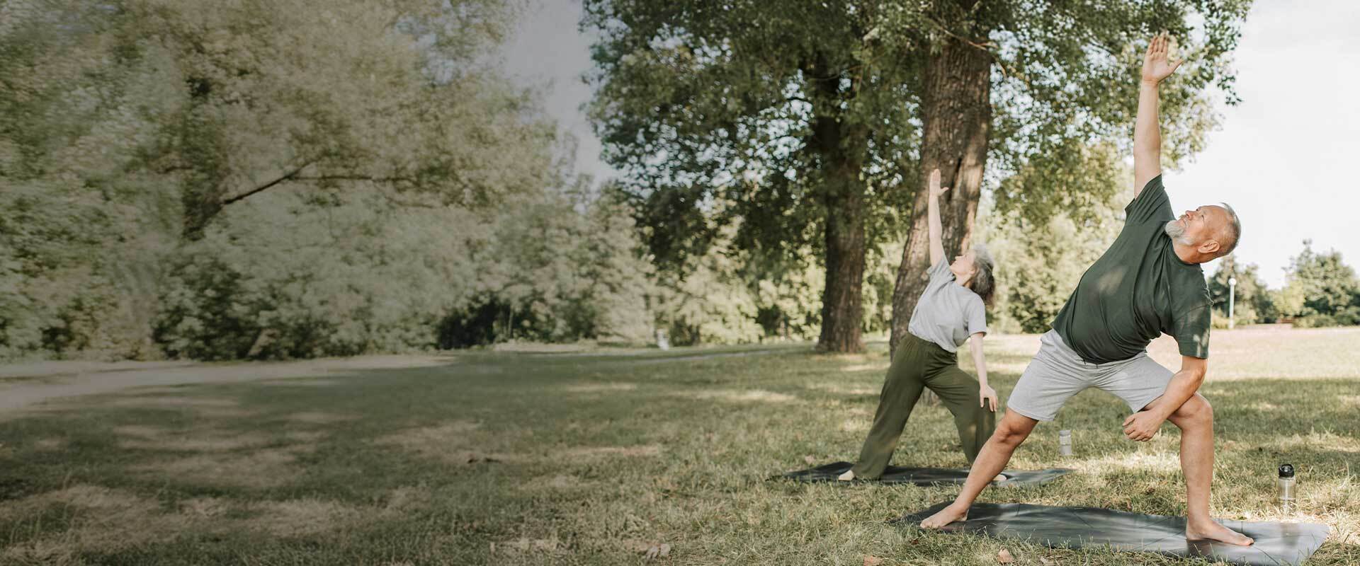 happy couple doing yoga outside