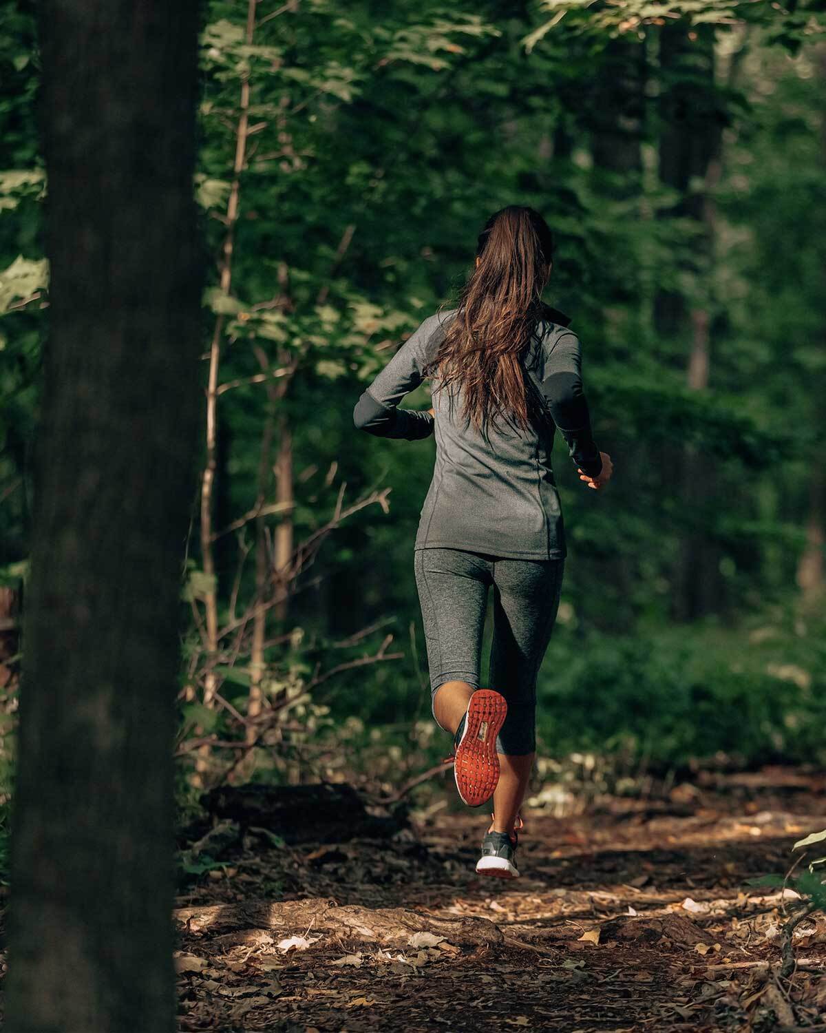 Woman running through a forest