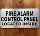 FIRE ALARM CONTROL PANEL LOCATED INSIDE COMPLIANCE SIGN WITH RAISED LETTERS/IMAGE NO BRAILLE