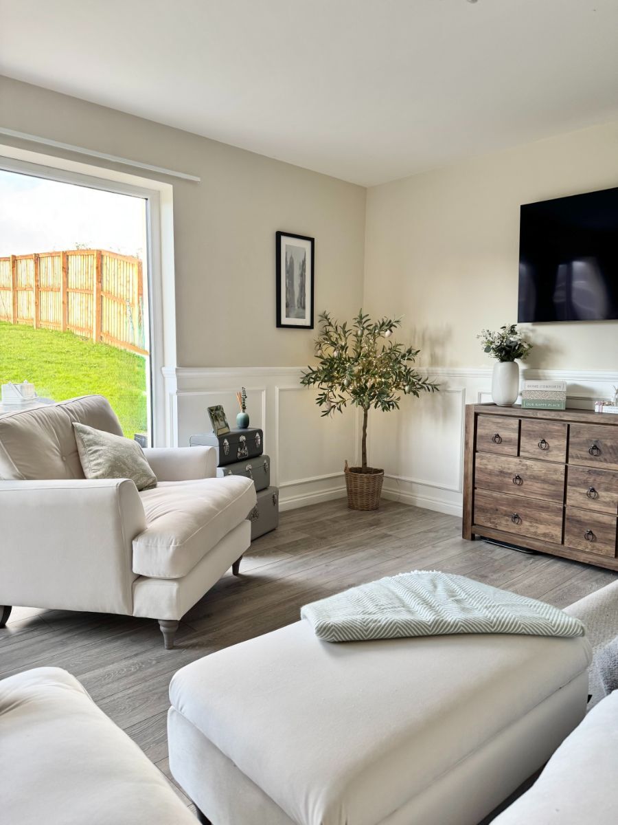 Angled view of the country-style living room showing the white half-wall wainscoting from a different perspective