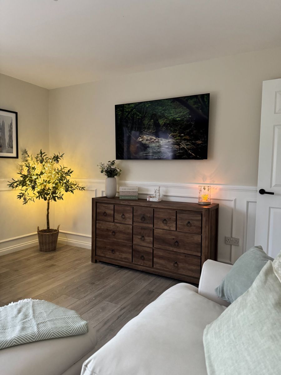Bright living room with white half-wall wainscoting providing a traditional accent to a country-inspired space