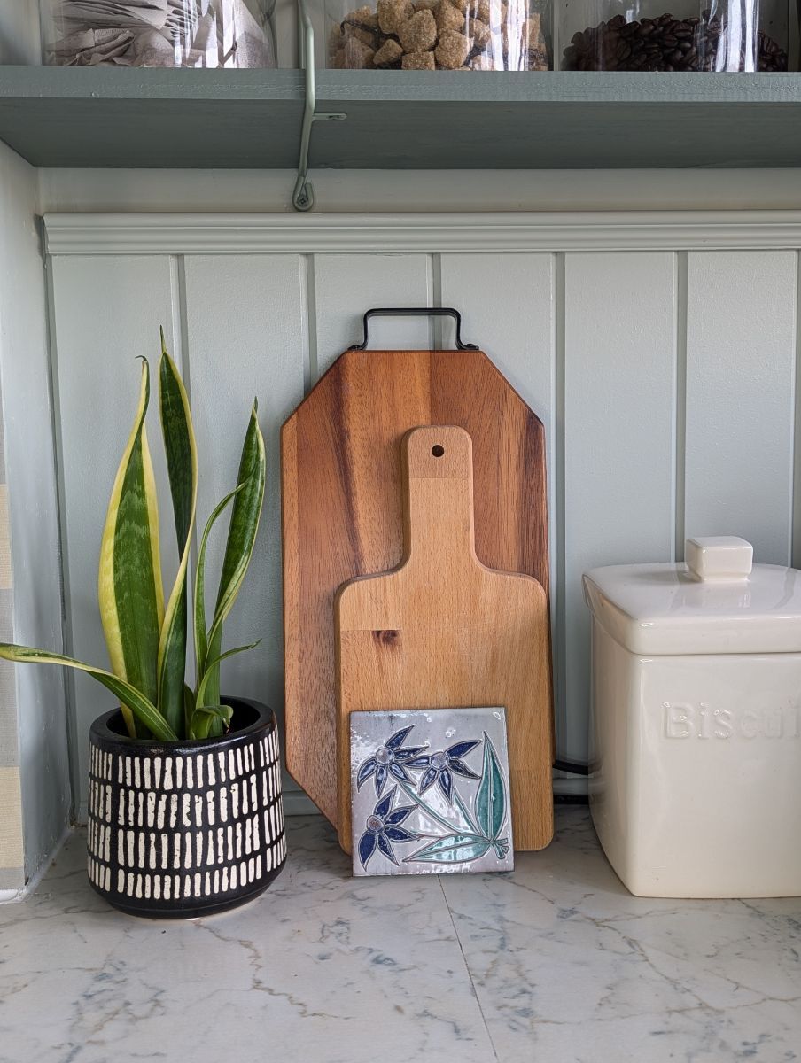 Kitchen with board and batten style panelling used as a splashback, creating a textured wall treatment behind the cooking area
