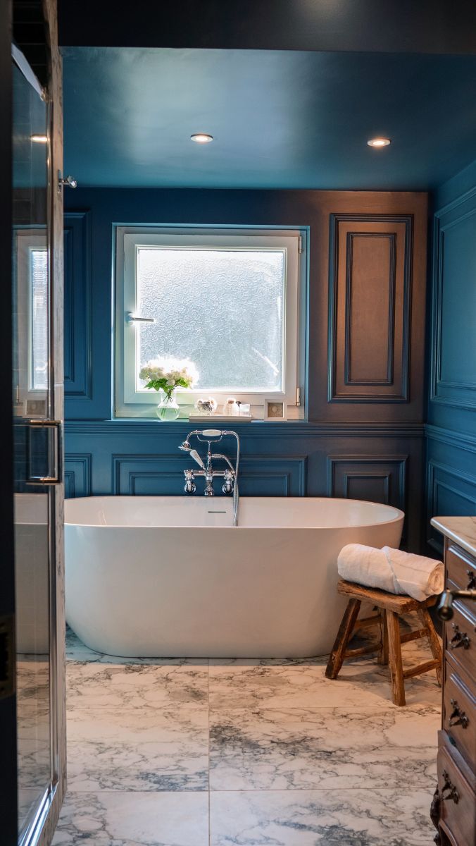 Straight-on view of the navy blue bathroom wainscoting showing the rich colour and wooden accents