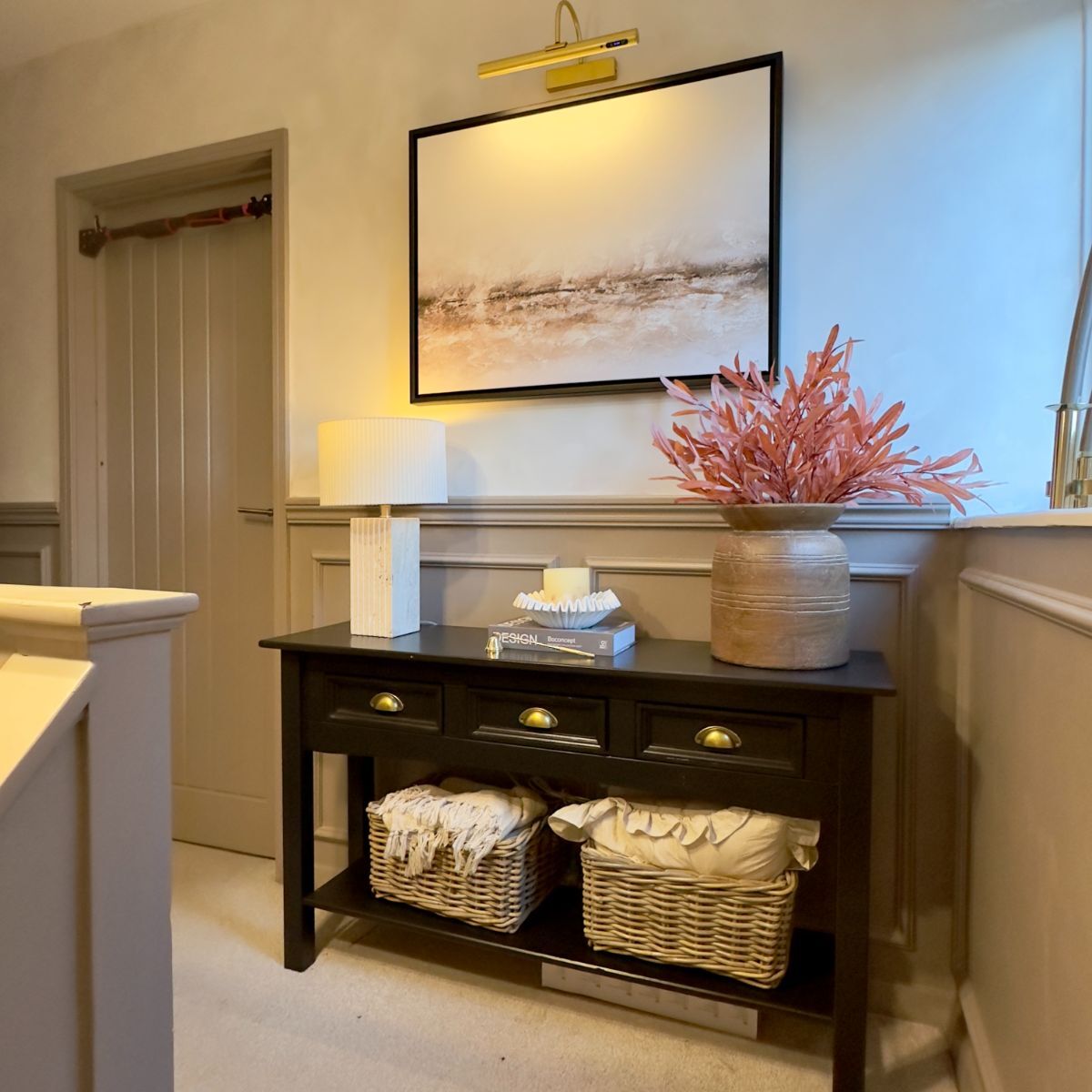 Landing area above stairs with half-wall wainscoting continuing the cohesive design throughout the stairway