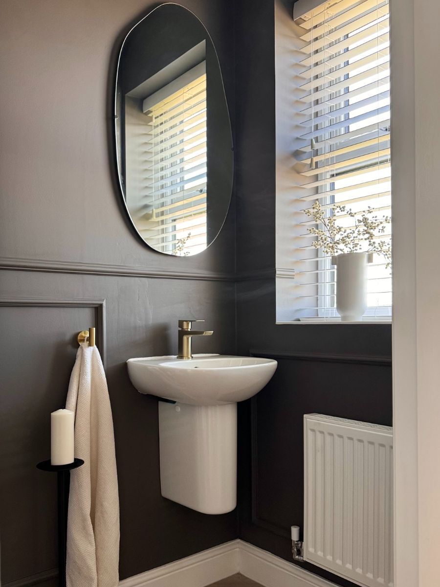 Dramatic bathroom with black wainscoting creating a bold contrast with white fixtures and walls