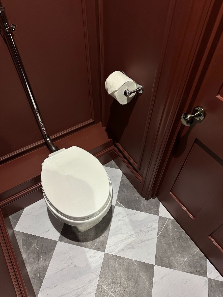Victorian-inspired bathroom with deep maroon wainscoting creating a rich, colour-drenched space