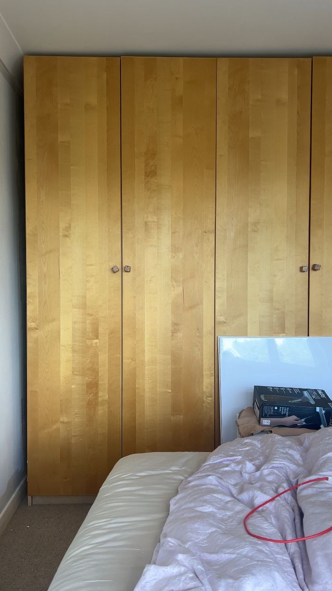 Before image of a plain, unadorned wardrobe with simple painted doors lacking architectural interest