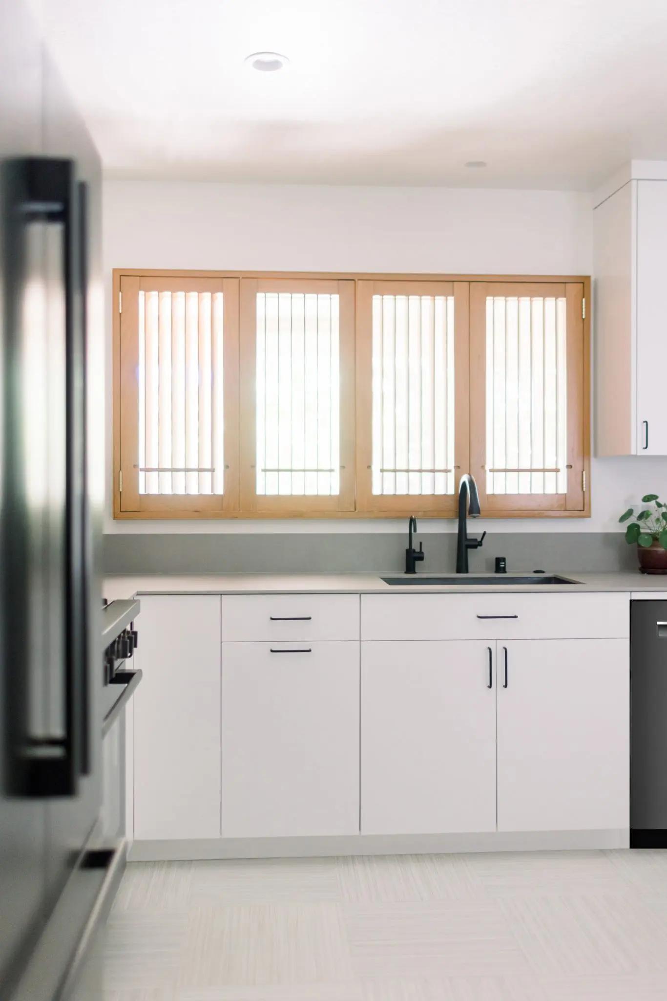 After renovation: Transformed kitchen corner with integrated appliances, clean lines and wooden accents in Japandi style