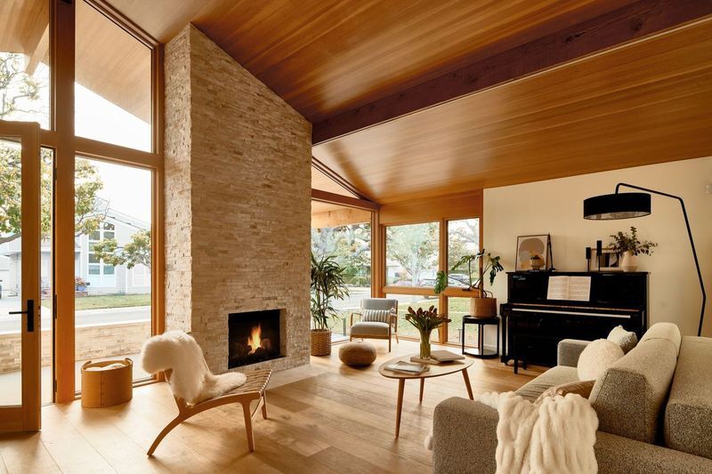 Japandi living room with expansive glass walls allowing natural light and indoor-outdoor flow with minimalist furniture