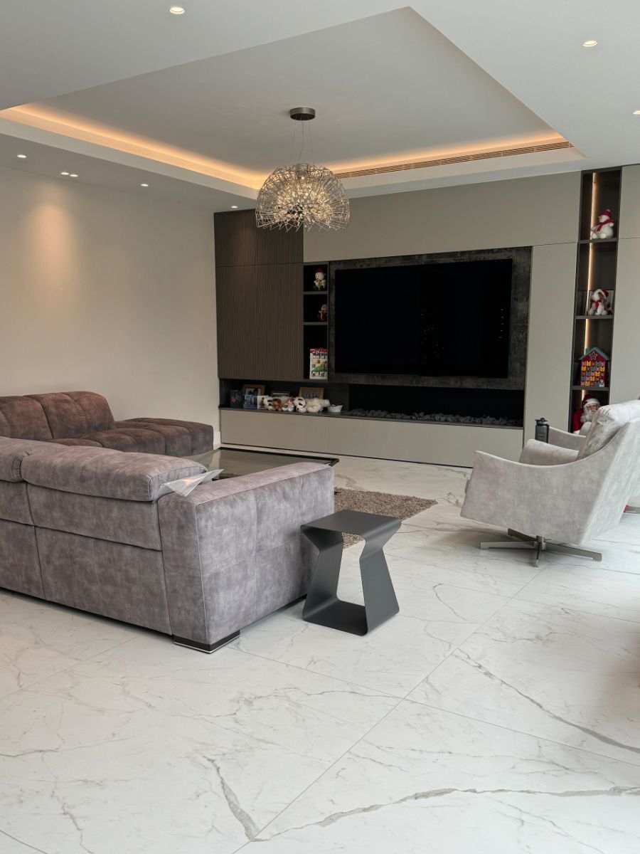 Contemporary media wall featuring wooden slat wall panelling adjacent to a wall-mounted television, creating a balanced asymmetrical design