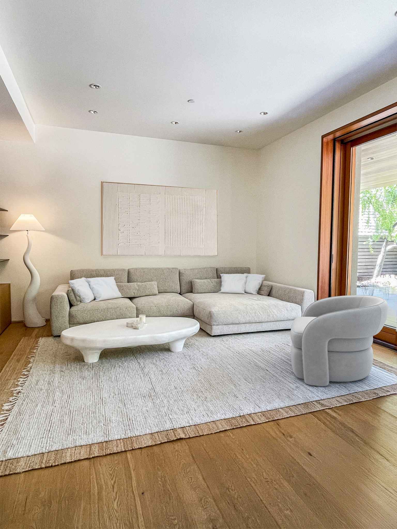 Japandi sofa and armchair arrangement with soft neutral textiles and natural wooden furniture elements
