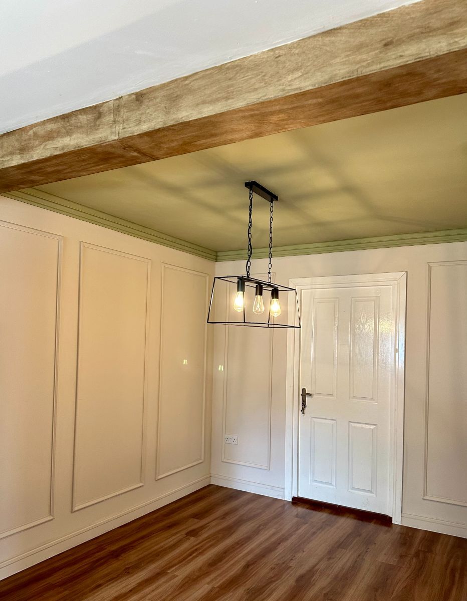 Clean, minimalist dining room with white full-wall single row panel moulding rectangles and wooden accent features