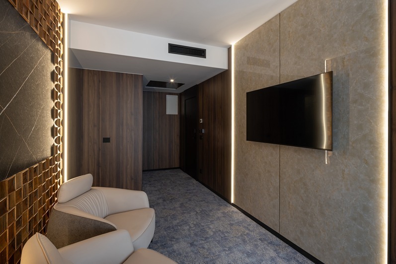 Atmospheric timber-panelled media wall with warm ambient edge lighting.