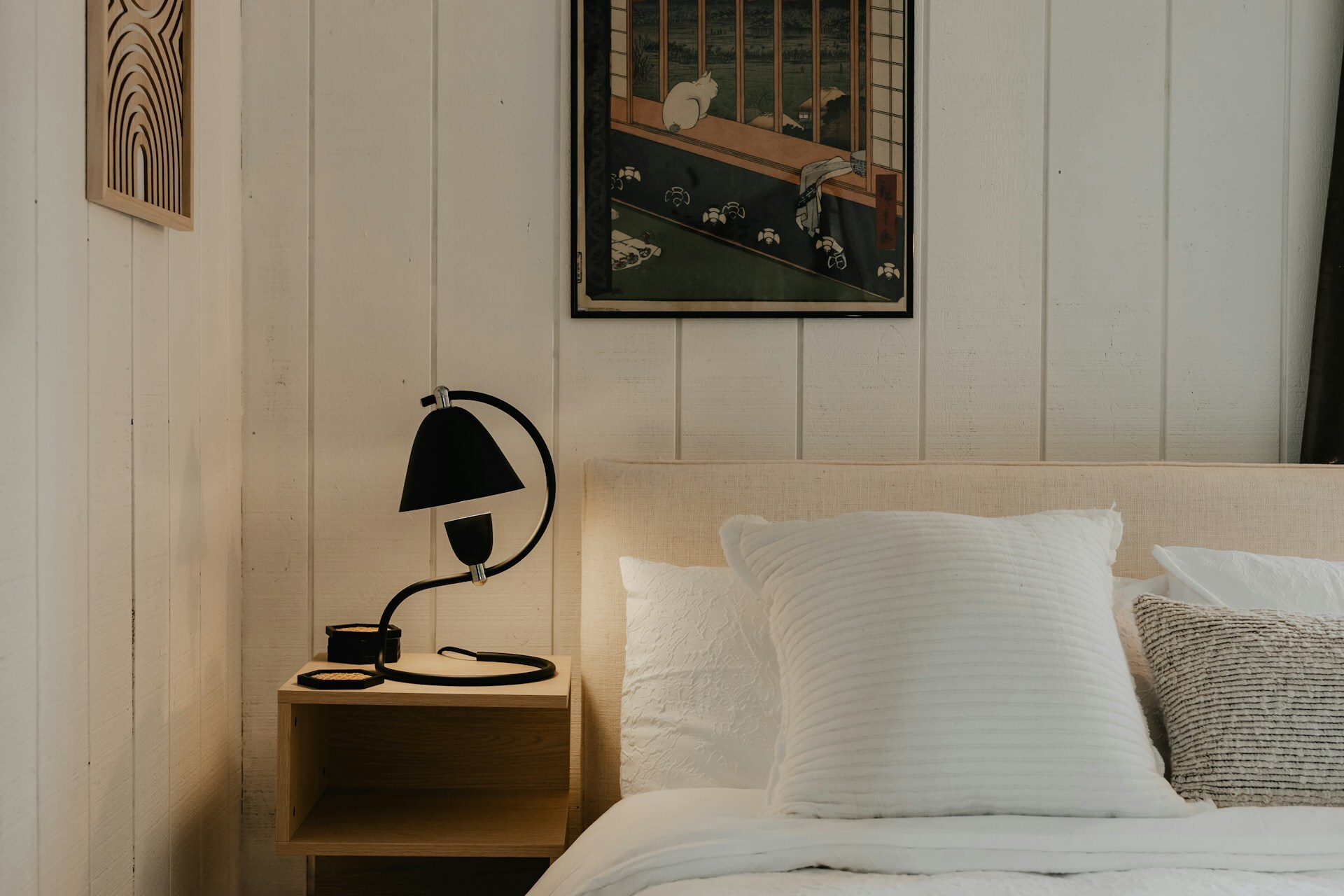 White painted vertical tongue and groove panelling behind bed with minimal Scandinavian styling