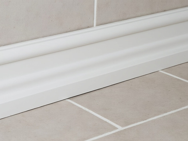 Skirting board installed between tiled floor and tiled wall