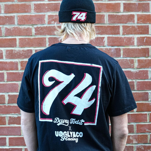 Celebrate the incredible achievements of Davey Todd with the '74' Tee, a vintage-inspired black t-shirt designed for fans of motorsport and timeless style. Celebrate the incredible achievements of Davey Todd with the '74' Tee, a vintage-inspired black t-shirt designed for fans of motorsport and timeless style.