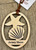 The ornament is approximately 3.25” x 2.75” on a suede cord for hanging. The natural color of the wood will vary depending on the natural grains and color of the wood. 