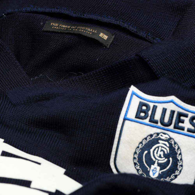 Close-up of the woven Carlton monogram logo on the VFL Wool Guernsey.