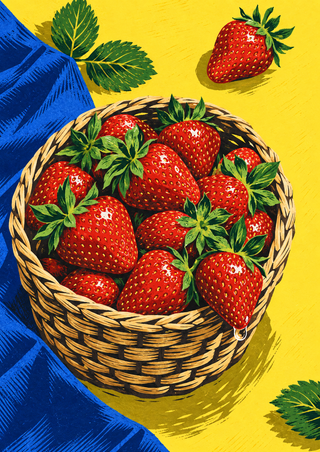 Woven basket overflowing with red strawberries on a yellow surface, with cobalt cloth, green leaves, and loose berries.