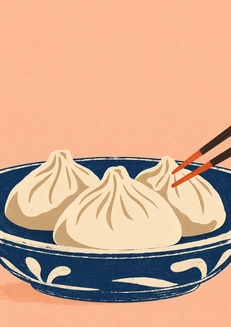Three cream pleated dumplings in a dark indigo serving dish with chopsticks entering from the right on a peach background.