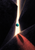 A turquoise sphere hangs in a narrow beam of warm light between dark slabs, with a coral shadow and fine saffron line.