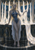 Pale-haired grey-skinned dark elf in blue gathering pearlescent silk from a many-spouted fountain in a night courtyard.