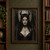 Pale, horned fantasy woman with pointed ears and dark wings, framed by thorn-like markings on her forehead and chest.; frame shown for styling only