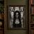 Front-facing woman with branchlike antlers, hanging charms, skull-like face paint, and dark markings against a distressed pale wall.; frame shown for styling only