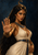 Dark-haired woman with a bronze scorpion ornament on her head, wearing a cream dress and blue-and-gold Egyptian-inspired jewelry.