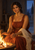 Seated woman in a rust-red dress warming her hands by a small open hearth as a doorway reveals a blue evening landscape.