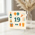 19th Birthday Card, Fun Celebration Design with Balloons, Bottle, Party Hat and Candles