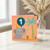1st Birthday Card - Cute Elephant with Party Hat and Number 1 Balloon, Jungle Theme with Gift and Palm - For Baby Boy or Girl