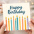 Happy Birthday Card - Colourful Candles Illustration with Bold Script Greeting - Cheerful Celebration Design for Friends, Family, Colleagues, Him or Her