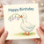 Happy Birthday Card - Cute Duck Holding Purple Bellflowers Illustration - Sweet Nature-Themed Animal Lover Design