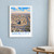 Sadr City city view bordered print styled in White frame / blue sitting room; frame and props not included
