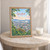 Guwahati city view full-bleed print styled in Oak frame / bedside table; frame and props not included