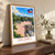 Jacmel city view bordered print styled in Original angled oak-console; frame and props not included