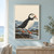Puffin with an orange bill and feet holding a small fish on a wet rocky tidepool shelf beside muted blue water.; frame shown for styling only