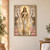 Crowned figure in a white-and-gold sari holding pink lotuses, flanked by elephants above reflective water.; frame shown for styling only